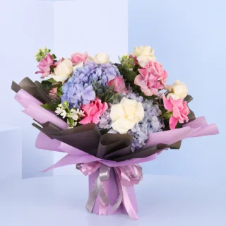 Hydrangea & Rose Bouquet featuring fresh pink roses, white roses, purple hydrangeas, oxypetalum, and eryngium beautifully hand-tied in premium floral wrapping for gifting and special occasions.