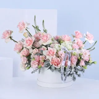 Pink Elegance Floral Hat Box featuring fresh light pink roses, dusty miller, light pink lisianthus, white veronica, and white hydrangeas beautifully arranged in a premium white hat box for gifting and special occasions.