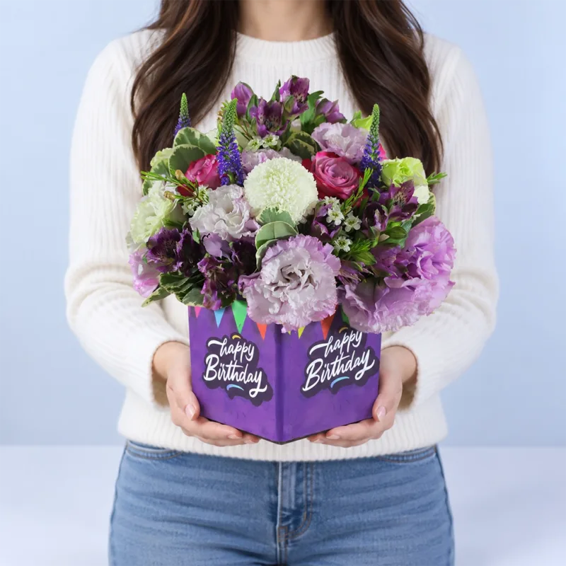 purple-birthday-bloom-box Purple Birthday Bloom Box featuring purple alstroemeria, deep purple roses, purple lisianthus, purple veronica, white ping pong flowers, purple wax flowers, and greenery.