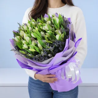Purple and white tulip elegance bouquet featuring fresh tulips with delicate purple white fillers, beautifully arranged in pastel purple wrapping for birthdays, anniversaries, celebrations, and gifting.