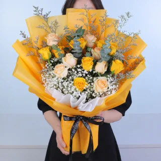 Yellow and peach rose bouquet featuring fresh yellow roses, peach roses, purple caspia, eucalyptus cinerea, and white gypsophila, beautifully arranged for birthdays, celebrations, friendship, and thoughtful gifting.