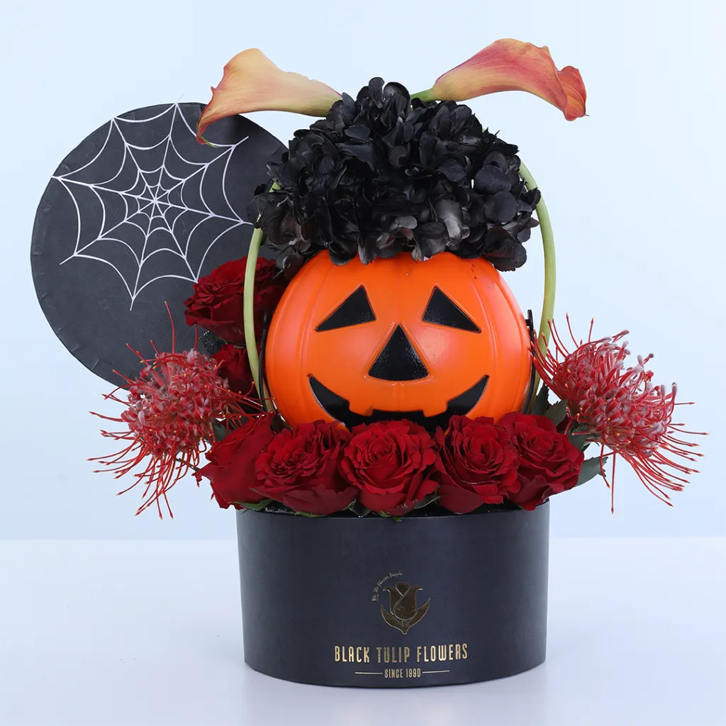 Unique Halloween Gifts Dubai: Pumpkin Flower Arrangements, Cakes and more 10 Haunted Pumpkin Halloween flower arrangement featuring seven red roses, two orange calla lilies, two painted hydrangeas, and Cordifolium foliage with a pumpkin centrepiece and spiderweb decoration.