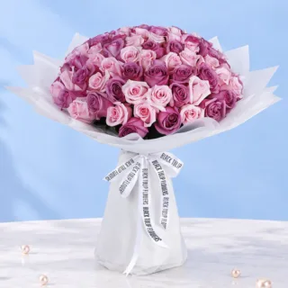 Twin-Tone 100 Roses Romance bouquet featuring vibrant purple roses and soft pink roses, arranged together in an elegant rounded design for heartfelt gifting and romance.