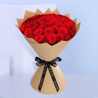 BTF Home 16 A premium bouquet of red roses elegantly wrapped in brown paper and tied with a black ribbon.