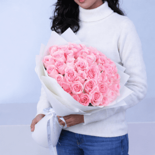 BTF Home 23 A sophisticated bouquet of gentle pink roses, elegantly wrapped and tied, showcases a full, lush floral display.
