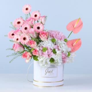 BTF Home 37 A soft pastel floral arrangement with layered blooms and fresh green accents, beautifully styled in a round white box.