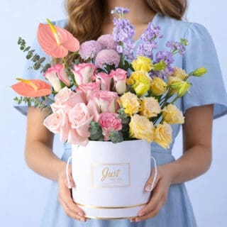 BTF Home 10 Pink roses, purple matthiola, peach anthurium, purple ping pong blooms, peach lisianthus, and eucalyptus in a white luxury round box, finished with a Just For You message label.